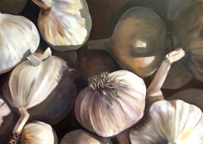 A monochromatic palette of off white, cream, light burgundy and dark blue greys. Garlics are in a container and the viewer sees them from above. They are strongly lit, casting strong shadows. The garlic stems form vertical lines to contrast the round organic shapes.