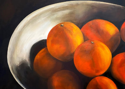 Vibrant orange tangerines are placed in an off white bowl, and the light creates strong shadows. An old world painting feeling, where the still life is quietly majestic.